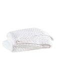 The Pinecone Hill Lodi Matelasse Coverlet, a neatly folded white cotton layer with a subtle diamond pattern, is displayed on a plain white background.