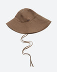 The Lois Twill Hat by Sea New York is an oversized brown sun hat with chin straps and "sea" embroidered in small, dark blue letters on the front, shown against a plain white background.