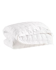 A neatly folded Pinecone Hill Lush Linen Puff Twin blanket with a soft, textured surface is displayed against a plain white background—an inviting bedding solution for any room.