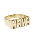 The Mama Ring by Faire features a bold, raised "MAMA" design in gold lettering. Its polished finish creates a striking look against the plain white background.