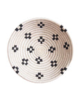 The Maraba Large Bowl by Amsha - Faire features a round, spiral pattern with black geometric designs evenly spaced on a light beige surface, photographed against a white background.