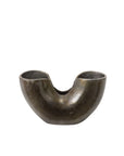 The 74705 Franz Vase by Accent Decor features a dark, metallic, sculptural design with a wide rounded base, two upward-facing sections divided by a central dip, and a textured, slightly reflective oxidized surface.