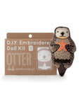 The Faire Otter Embroidery Kit is a DIY set featuring an embroidered otter holding an orange star, with an otter design shown on the brown cardboard package along with the kit details.