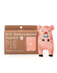 The Faire Pig Embroidery Kit is a level 1 beginner set with materials to craft a pink pig plushie with a blue bow tie. The packaging shows an illustration of the finished pig and highlights its suitability for embroidery novices.