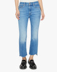 A person wears the Mother Lil Insider Crop Step Fray jeans in light blue stretch denim with high waist and frayed hems, paired with black loafers. The photo is cropped from waist to feet against a plain white background.