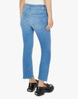 A person is shown from the back, standing against a plain white background, wearing Mother Lil Insider Crop Step Fray high-waisted light blue jeans with a slightly frayed hem and black loafers.