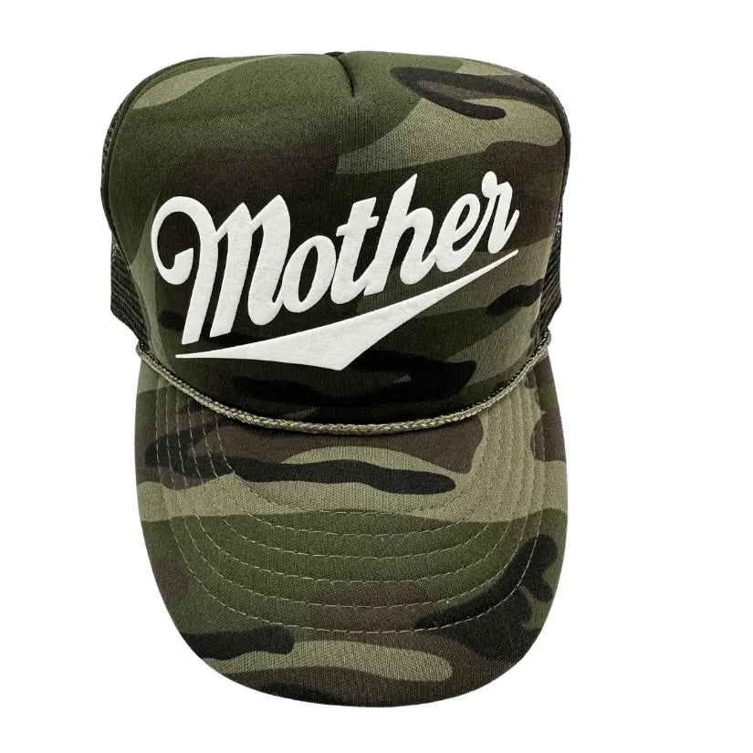 A camouflage Faire Mother Summer Trucker Hat with the word "Mother" written in bold, white, cursive letters on the front. The cap features a flat brim and an adjustable snap at the back.