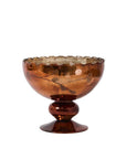 The Naomi Compote by Accent Decor is a vintage amber glass pedestal bowl featuring a scalloped rim and decorative swirls that reflect light beautifully on its glossy surface.