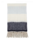 Striped throw blanket with cream, light blue, and dark gray bands and fringed ends by POM POM for Bungalow Furniture.