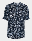 The Apiece Apart Los Altos Top is a navy blouse with a white abstract print, short ruffled sleeves, high round pleated neckline, and relaxed fit.