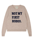 The Rodeo Crew by Jumper 1 2 3 4/CR2 is a beige crew neck sweater featuring "NOT MY FIRST RODEO." boldly printed in navy blue across the front.