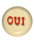 Beige enamel tray with bold red OUI lettering, Faire, Round Enamel Tray Oui, decorative accent for the home.