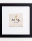 Framed Art Square Blk Frame from Match South. The Art Square Blk Frame is cream-colored with gold and black text displaying a crest logo and the words "The Plaza New York" in elegant script. Enclosed in a clear acrylic frame with a white background, it exudes timeless elegance.