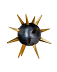 The Punk Candleholder by The Import Collection features a dark metallic sphere with gold spikes of varying lengths, radiating edgy elegance and modern style against a white background.