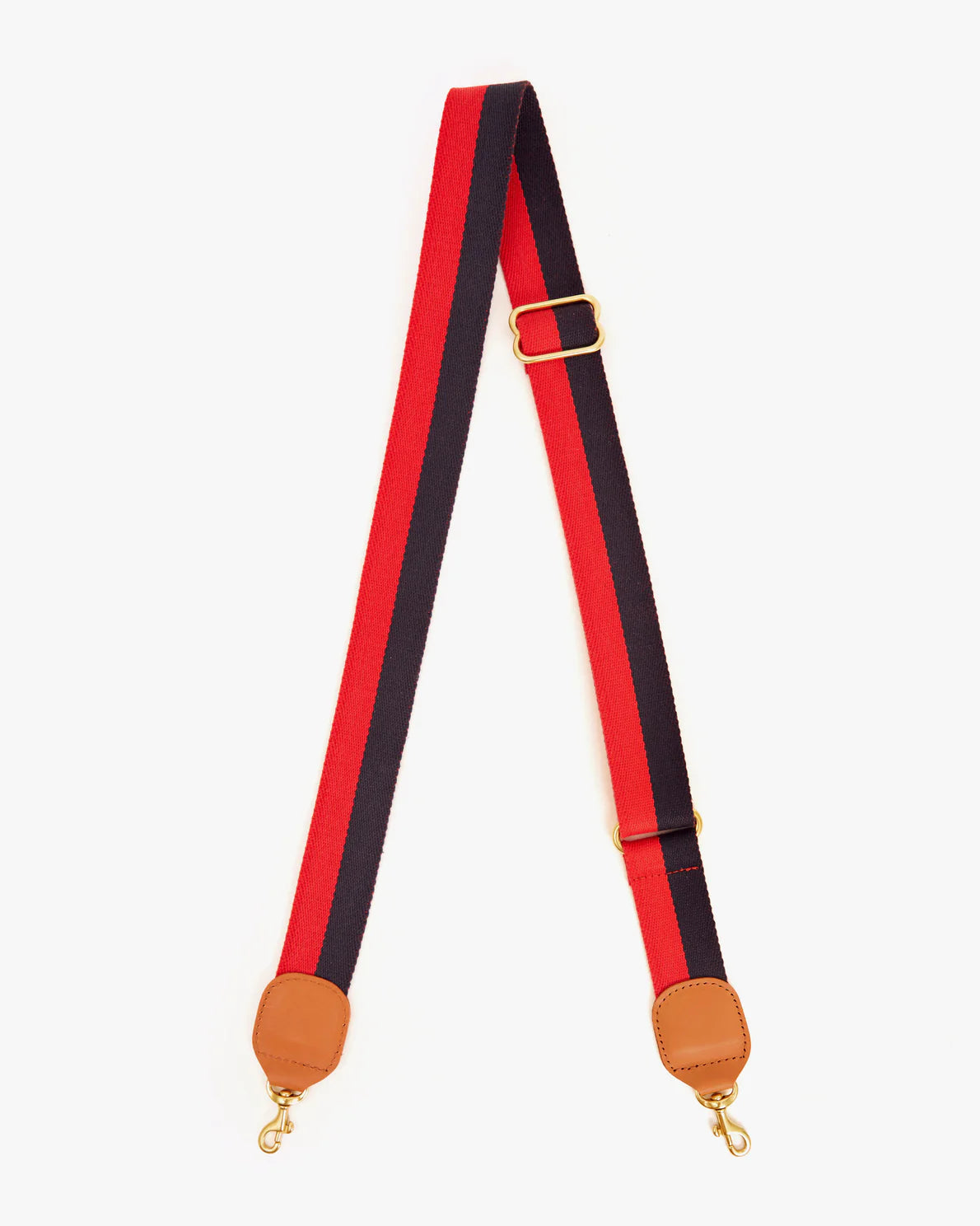 A pair of red and navy striped Crossbody Straps by Clare Vivier with leather attachments and brass snap hooks, displayed against a white background.