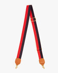 The Clare Vivier Crossbody Strap S24 features red and navy striped nylon webbing, adjustable length, tan leather trim at the ends, and gold metal clasps.