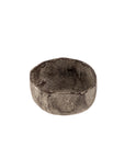 The Indaba 1-0882 Rustica Bowl S is a small, round, shallow aluminum bowl with a textured, uneven dark finish. Handcrafted in India using sand casting, it features a rustic, stone-like look and artisan appeal.