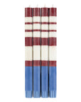 The Faire Striped Guardsman Red & Royal Blue Candles S/2 feature bold red and white stripes at the top with a solid royal blue base, hand-poured for a stunning finish and displayed side by side against a white background.