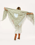 Cotton knit poncho with drippy heart design by Kerri Rosenthal, shown from the back, styled with boots.