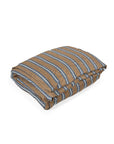The Salem Duvet by Libeco Home, crafted from 100% linen, features a brown base with blue and white horizontal stripes and is shown folded on a white background.