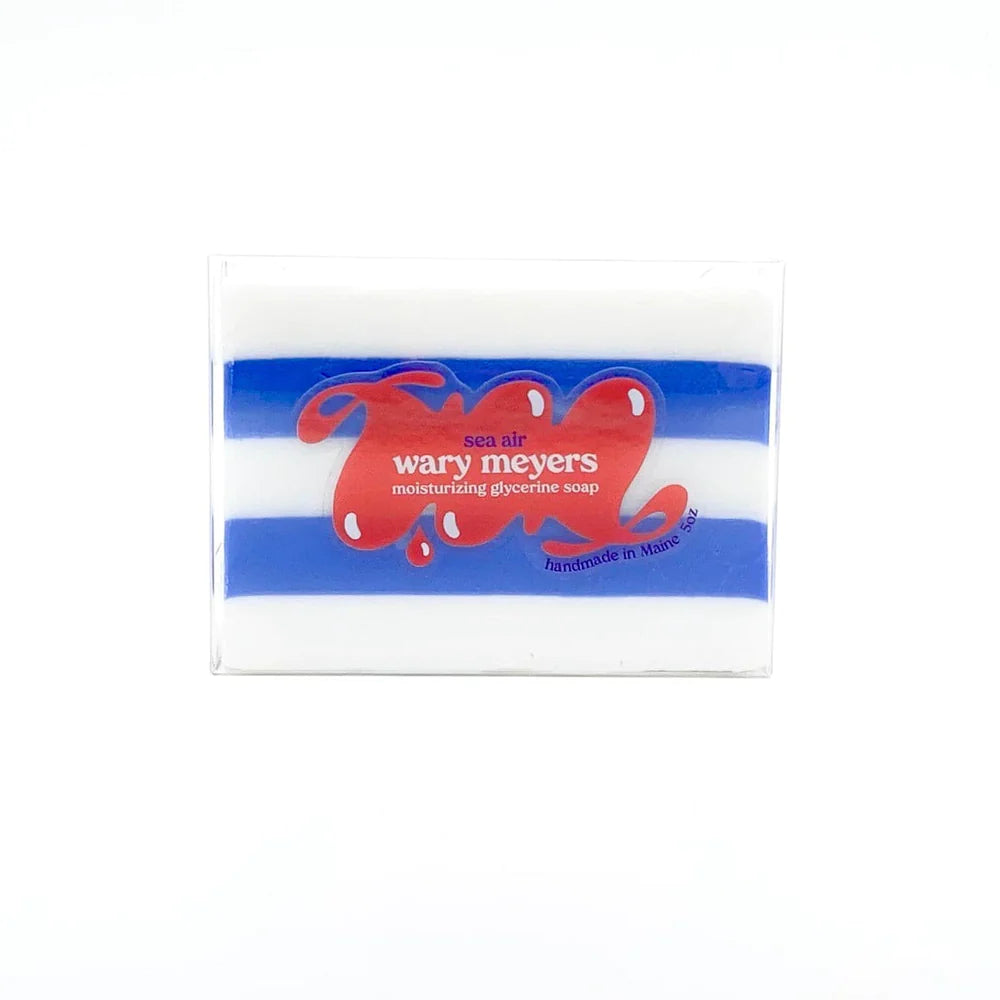 A bar of handmade moisturizing glycerine soap in clear packaging, featuring blue and white stripes with two red hearts. The text &quot;Wary Myers Scottsdale Arizona bungalow moisturizing glycerine soap&quot; is displayed.
