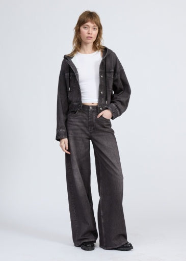A person with straight light brown hair and bangs wears the Rag & Bone miramar terry hood trckr jckt, matching wide-leg jeans, a white crop top, and black shoes against a plain background for an effortless Miramar-inspired look.