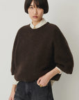 Sessun Tallon Long Sleeve Sweater and striped shirt styled with dark jeans, modern casual look on plain background.