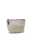 The Kempton & Co. Makeup Bag is a small, soft, cream-colored natural shearling bag with a fluffy, textured surface and a dark zip top closure, displayed against a plain white background.