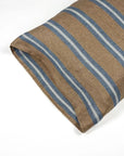 A close-up of the Libeco Home Salem Pillow Case shows its brown fabric with blue and white stripes, neatly folded on a white surface.