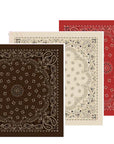 Three Silk Bandanas by The Great Inc. overlap—front brown, middle white, back red—each featuring intricate paisley and floral patterns along the border and center.