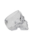 The Accent Decor Reaper Pot, a clear glass tumbler shaped like a human skull, makes a spooky planter or witchy decor piece and is shown lying on its side against a white background.