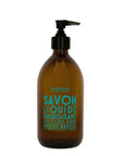 A brown glass pump bottle labeled "Liquid Soap 16.7oz" features a blue label with black text reading "Cie Luxe Brands" and "Uplifting Soap." This soap is infused with revitalizing vegetable oils.