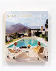 The cover of "Slim Aarons: Women" by Hachette Book Group features elegant women in white outfits lounging poolside, with a modern house and mountains reflecting the high society glamour of the iconic photographer's work.