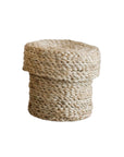 The Faire Round Lidded Jute Basket is a handwoven, light-colored storage basket with a lid, crafted from natural jute and shown against a white background.