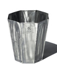 The Faire Steel Trashcan is a tall, octagonal recycled steel container with a flared rim, riveted base, and embossed logo and text on the front, evoking vintage oil cans and casting a shadow on a white background.
