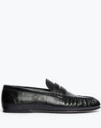 The Freda Salvador Sydney Crinkle Loafer, a black Italian leather shoe with a penny strap and moccasin-style stitching, is shown in profile against a plain white background.
