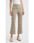 Wearing Rag & Bone’s irina ponte kick flare in beige and brown plaid with a white sleeveless top and cream loafers, this look against a white background is effortlessly chic—ideal for transitioning from office to evening.