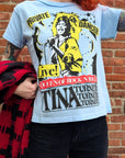 Wearing the DayDreamer Tina Turner 1985 Reverse DF Tee, featuring a vintage-style “Private Dancer Live!” graphic—this light blue band t-shirt is a must-have music fan collectible.