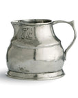 The Vintage 1815 Pitcher by Faire is a handmade, silver-toned Italian pewter piece with a wide base, narrow opening, curved spout, single handle, visible tarnish, and engraved marking on its side.