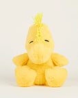 The Woodstock Warmies by Warmies/Intelex is a yellow microwavable plush toy with closed embroidered eyes and a tuft of yellow yarn hair, offering soothing warmth and comfort when heated.