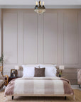 POM POM Whistler Throw adds cozy texture to a modern beige bedroom with a neatly made bed and white pillows.