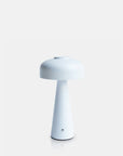 The Abigail Ahern T3-001 Adelaide LED Lamp is a modern, minimalist white dimmable portable light featuring a round mushroom-shaped shade and conical base, shown against a plain light gray background.