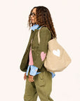 Green Kerri Rosenthal blazer with pink heart, styled with a beige tote for a fresh, modern look.