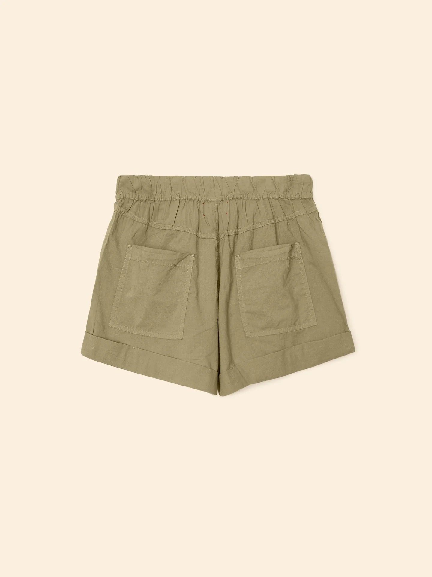 The Declan Short by Xirena in khaki green cotton poplin features an elastic drawstring waist, two back patch pockets, and folded cuffs, shown flat on a beige background.