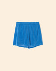 The Shayden Short by Xirena features a bright blue hue in a soft cotton blend with an elastic waist, shown flat on a beige background.