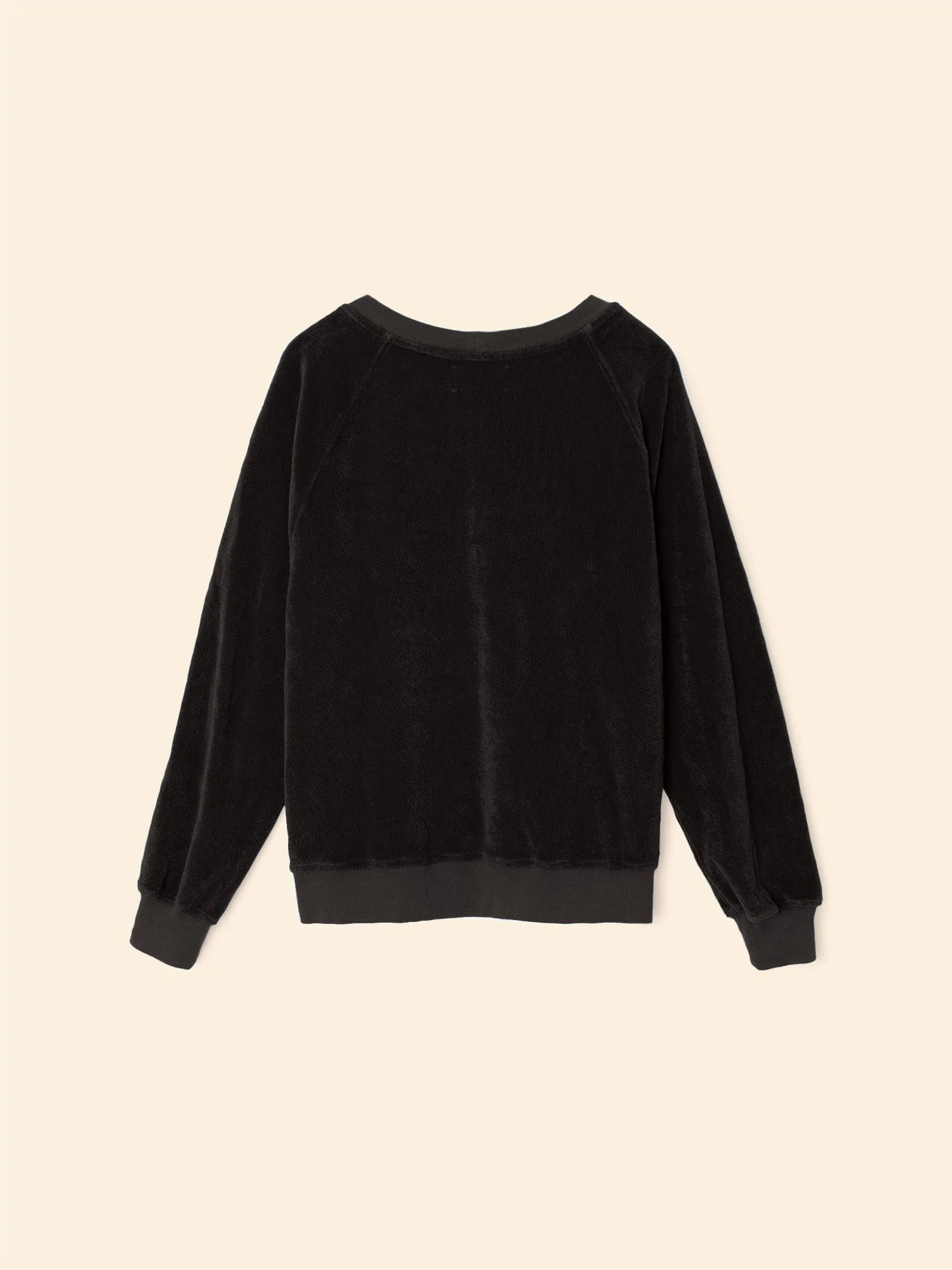 The Hopper Sweatshirt by Xirena is a black, long-sleeve velvet pullover with a crew neck and ribbed cotton-blend cuffs, neckline, and hem. Shown laid flat on a light beige background.