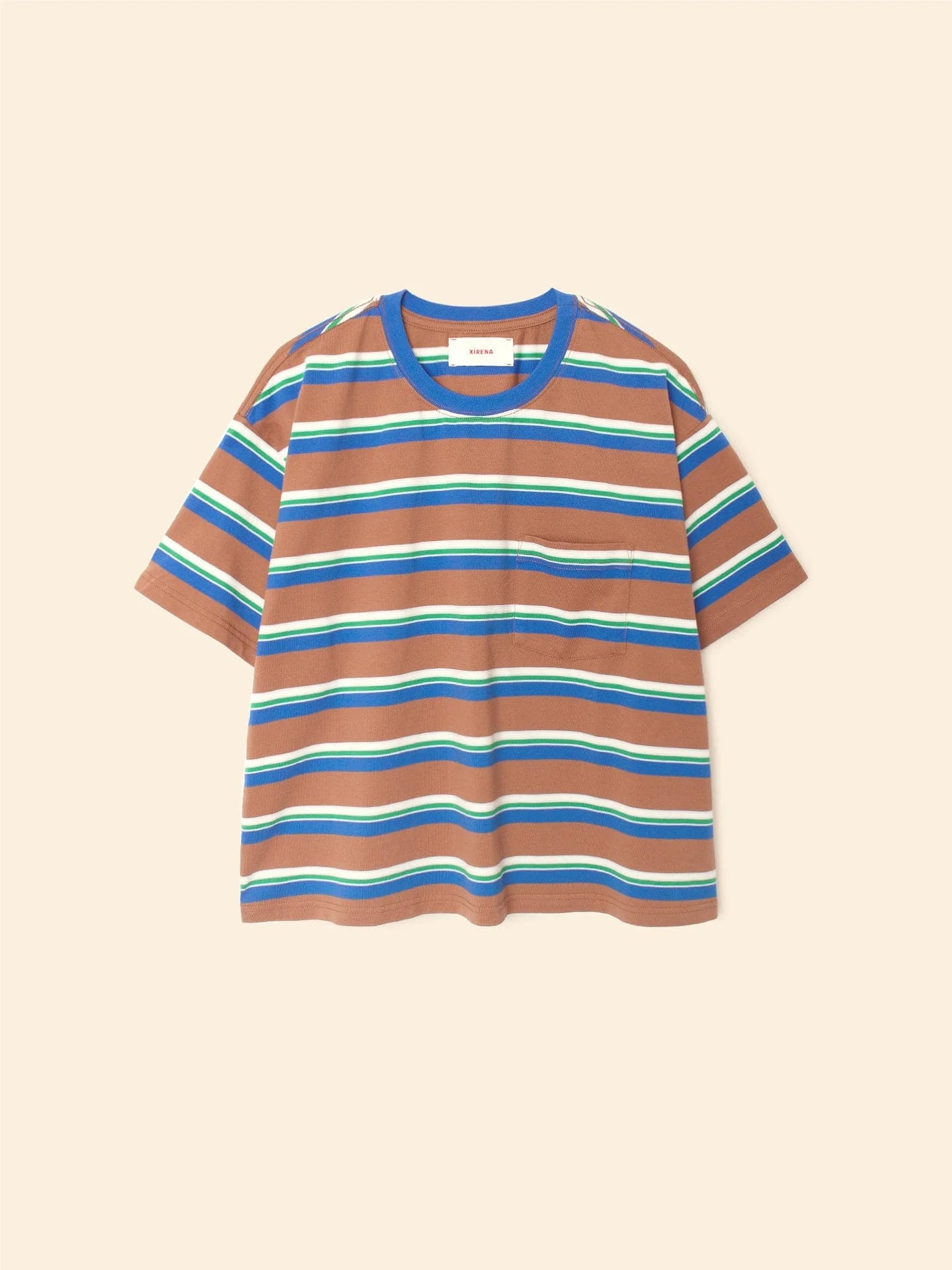 The Xirena Paulina Tee is a short-sleeved cotton jersey T-shirt in brown with blue, green, white, and yellow stripes. It has a contrast ringer neck and a left chest pocket, shown laid flat on a beige background.