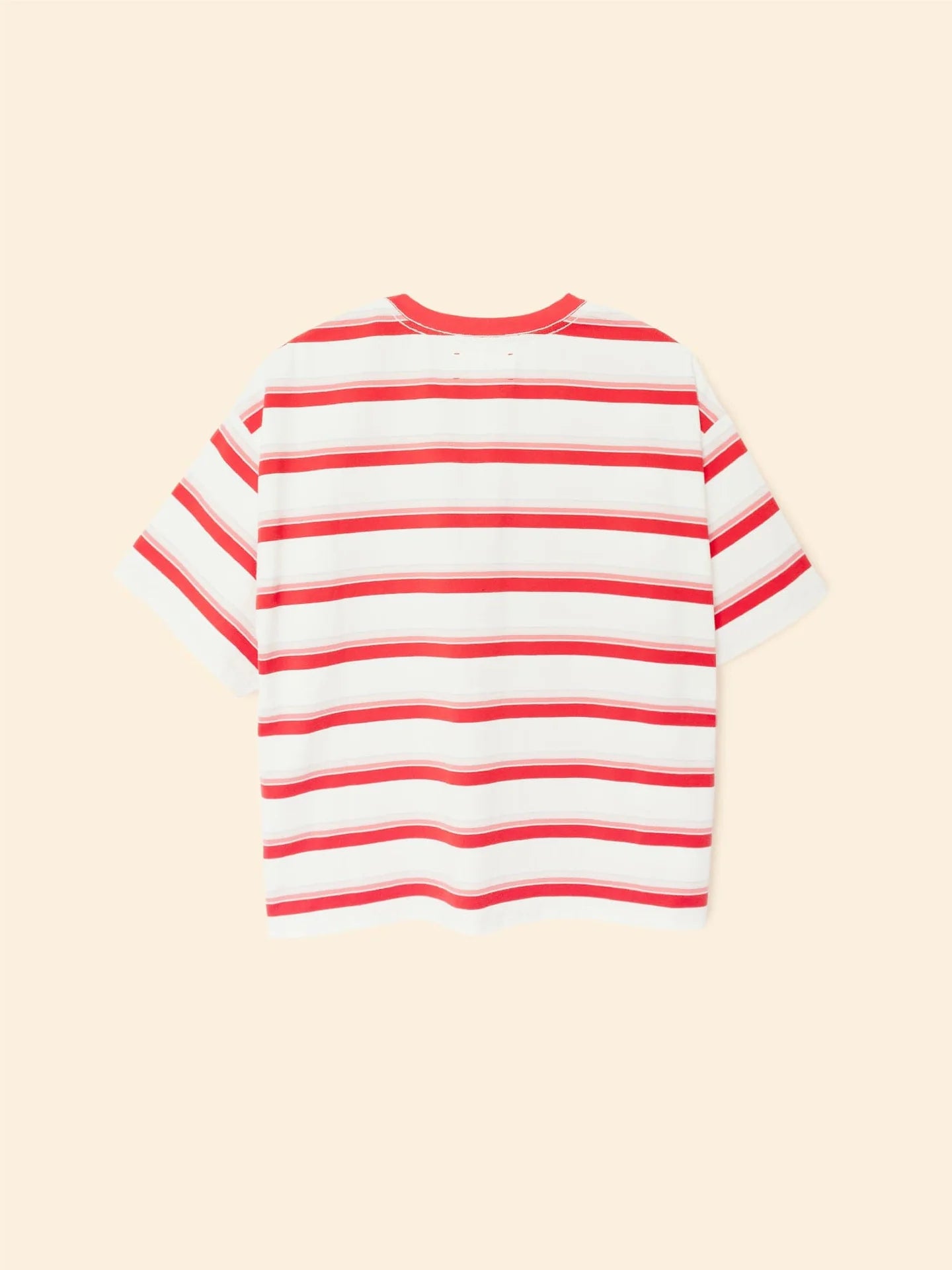 The Paulina Tee by Xirena is a short-sleeved, white cotton jersey t-shirt with horizontal red stripes, shown flat on a beige background. It has a relaxed, boxy fit and a classic crew neckline.