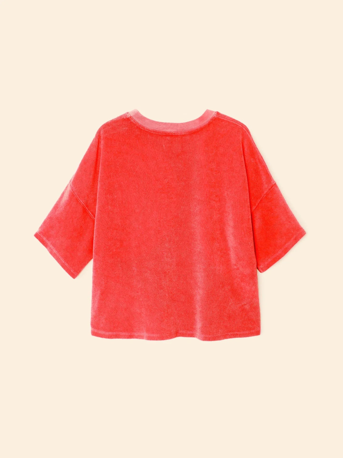 The Xirena Roe Top, a loose-fitting, short-sleeved Towel Terry shirt in bright red cotton blend, is shown from the back and displayed flat on a light beige background.