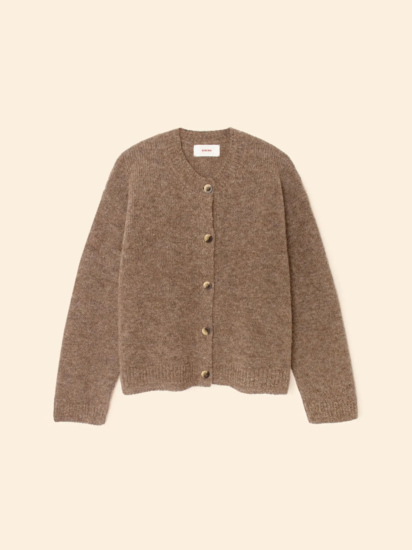 The Cameron Sweater by Xirena, a brown long-sleeve baby alpaca cardigan with a round neckline and soft textured fabric, is shown laid flat on a light beige background.